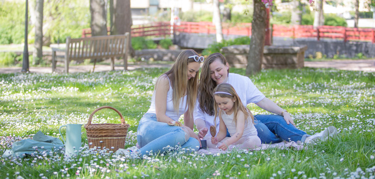 Två unga kvinnor och en yngre flicka på picknick på Turbinhusön