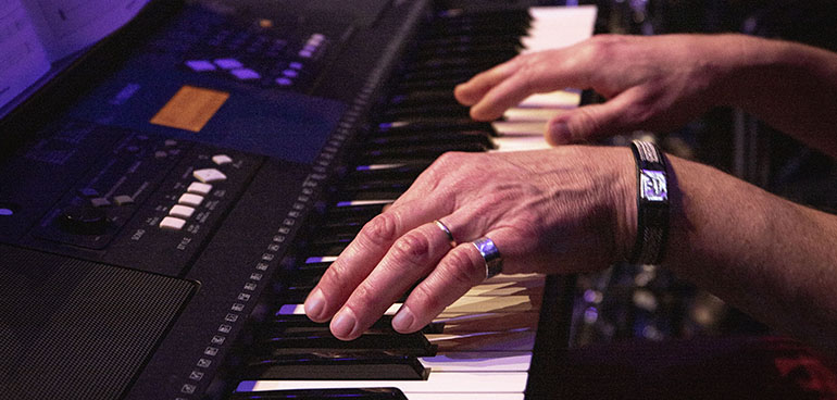 Närbild på händer spelandes piano